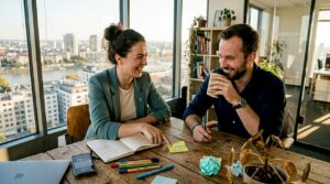 Dvaja marketéri v jasnej, presvetlenej kancelárii spoločne vymýšľajú nové nápady.