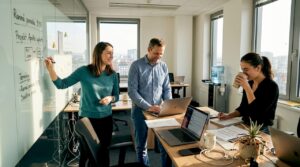 Kolegovia sa počas neformálneho stretnutia v kancelárii rozprávajú o tímovej spolupráci.