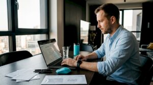 Muž sedí za jedálenským stolom a nastavuje si reklamy na Googli.